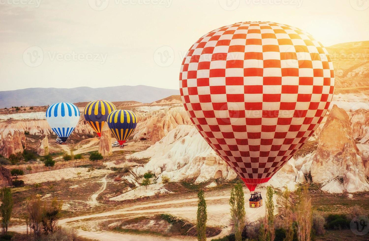 Hot air balloon flying over rock landscape at Turkey. Cappadocia photo