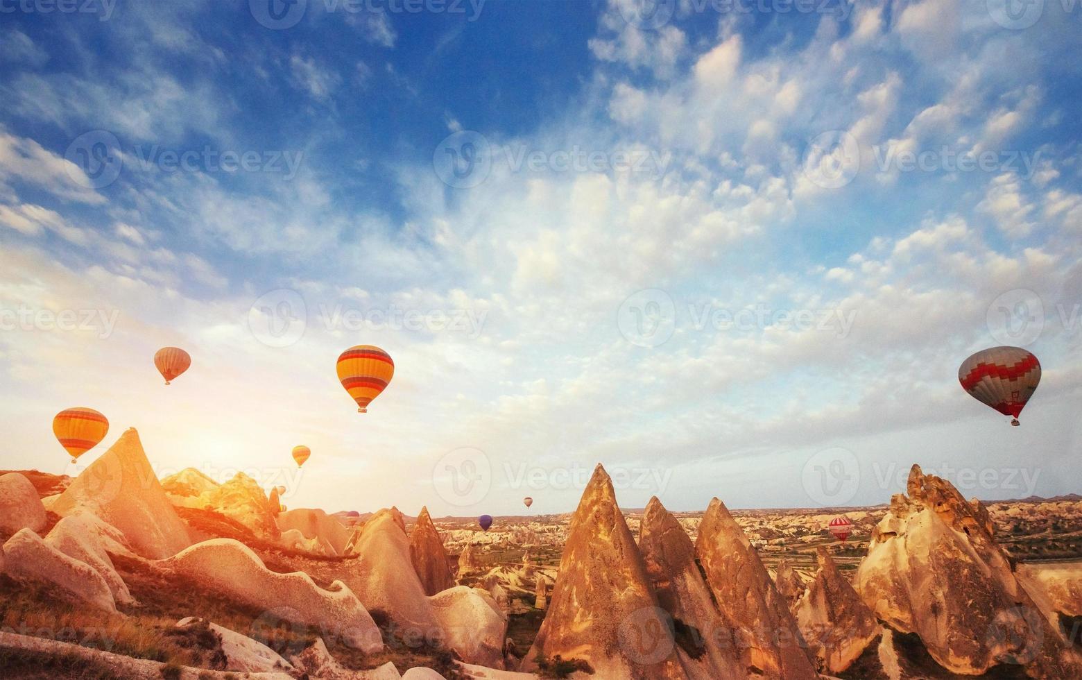 Hot air balloon flying over rock landscape at Turkey. Cappadocia photo