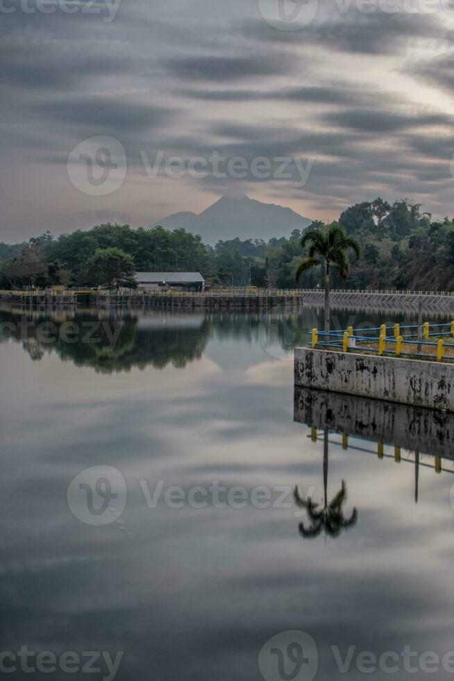 Panoramic reflection, Beautiful scenery Tambakboyo dam at sunrise with motion clouds photo