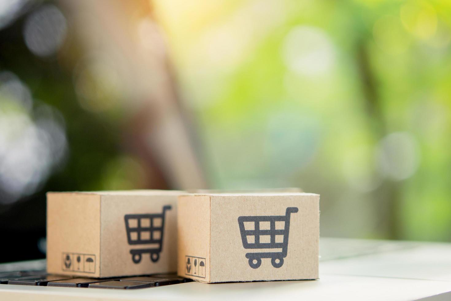 Shopping online. Cardboard box with a shopping cart logo on laptop keyboard. Shopping service on The online web. offers home delivery. copy space photo