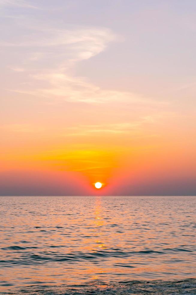 reflejo del atardecer mar. hermosa puesta de sol detrás de las nubes y el cielo azul sobre el fondo del paisaje del mar foto