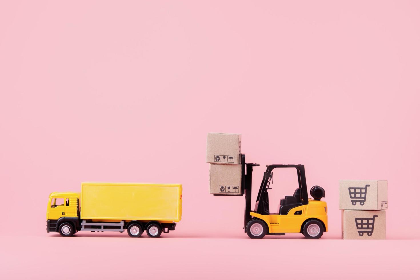 Logistics, and delivery service - Cargo truck, Forklift and paper cartons or parcel with a shopping cart logo on Pink background. Shopping service on The online web and offers home delivery photo