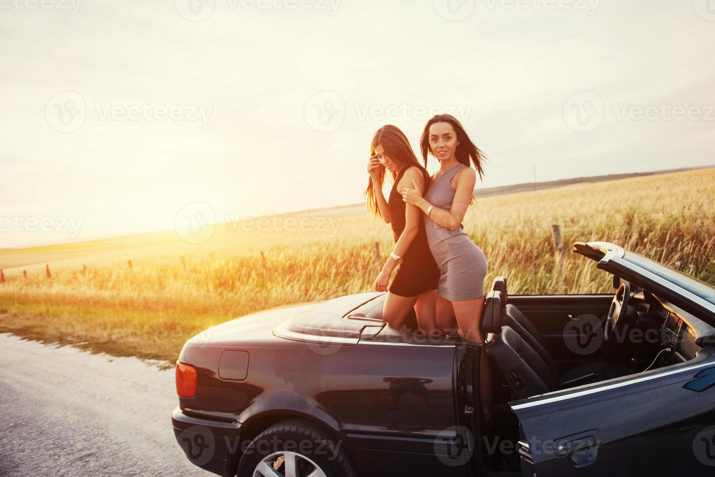 Two women in a black car on the roadside roads photo