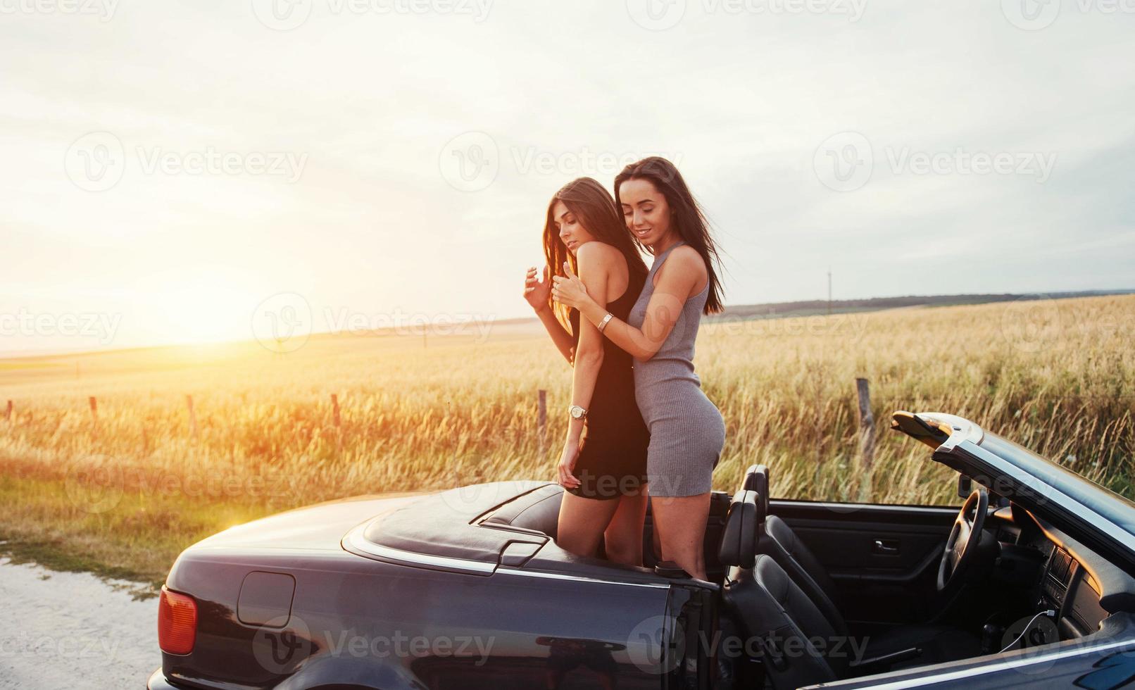 Two women in a black car on the roadside roads photo