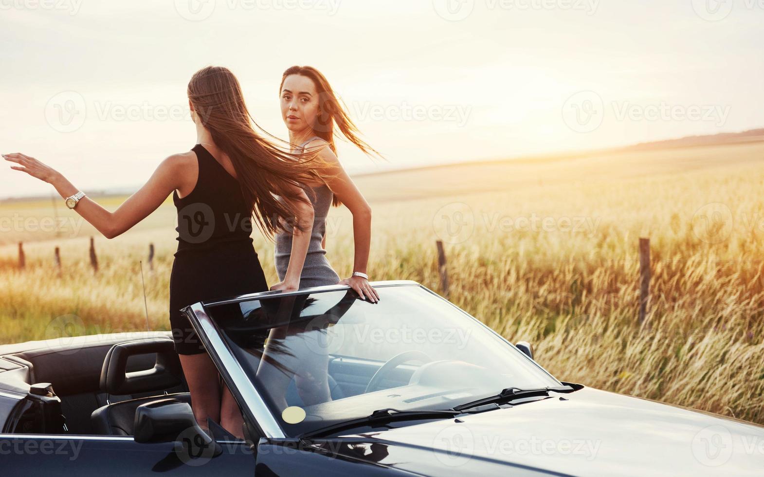 Two women in a black car on the roadside roads photo