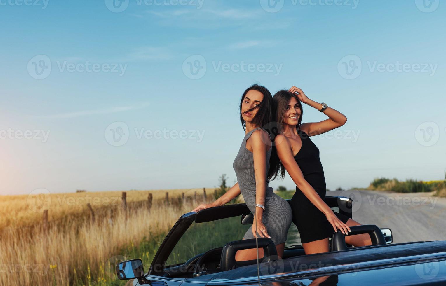 Beautiful two women sitting in a convertible photo