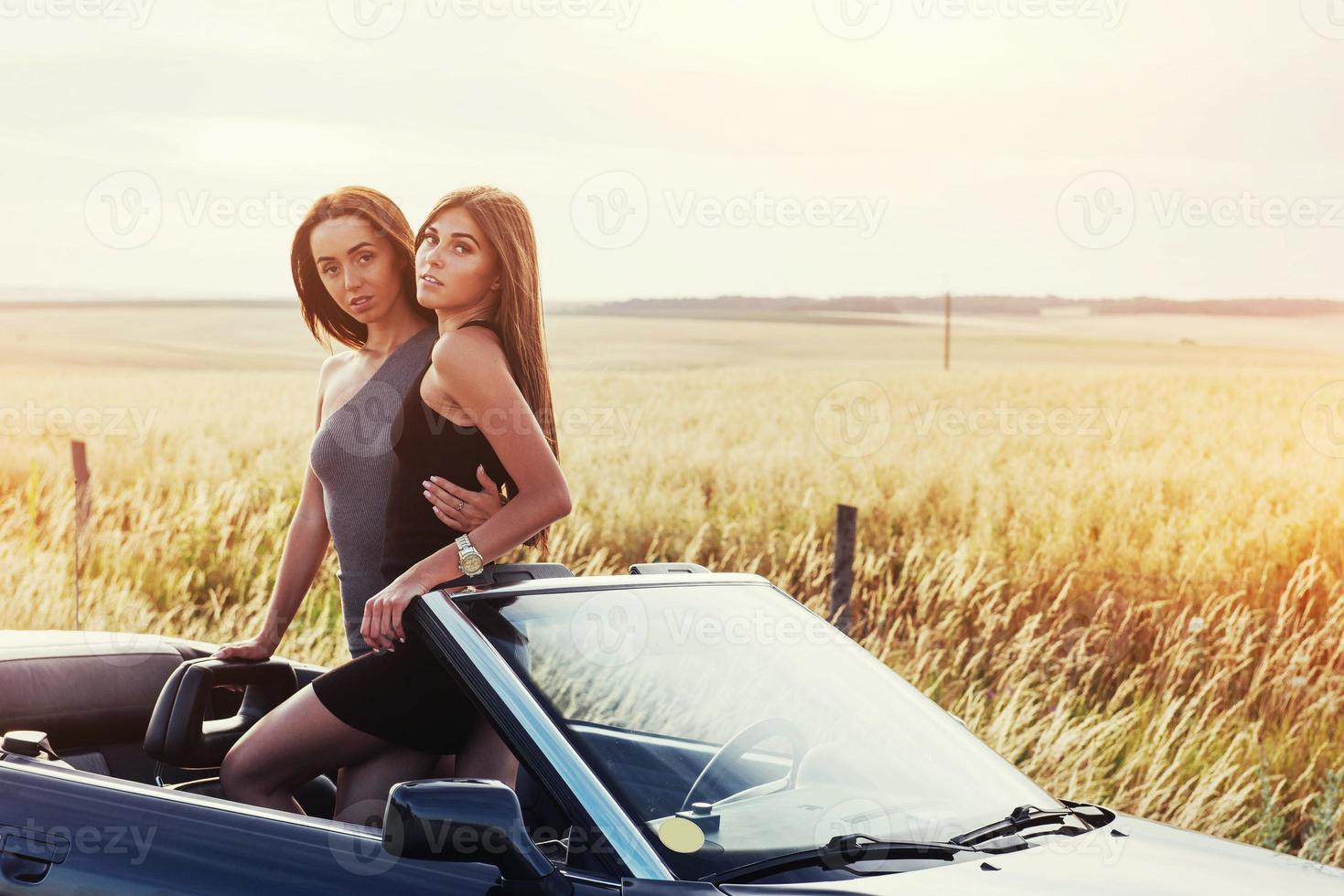 Girls posing for the camera in a black convertible photo