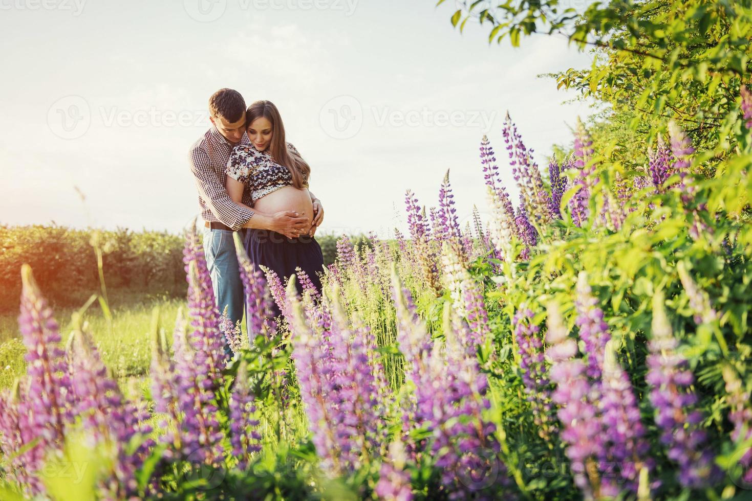 hermosa chica feliz embarazada de su marido al aire libre. foto