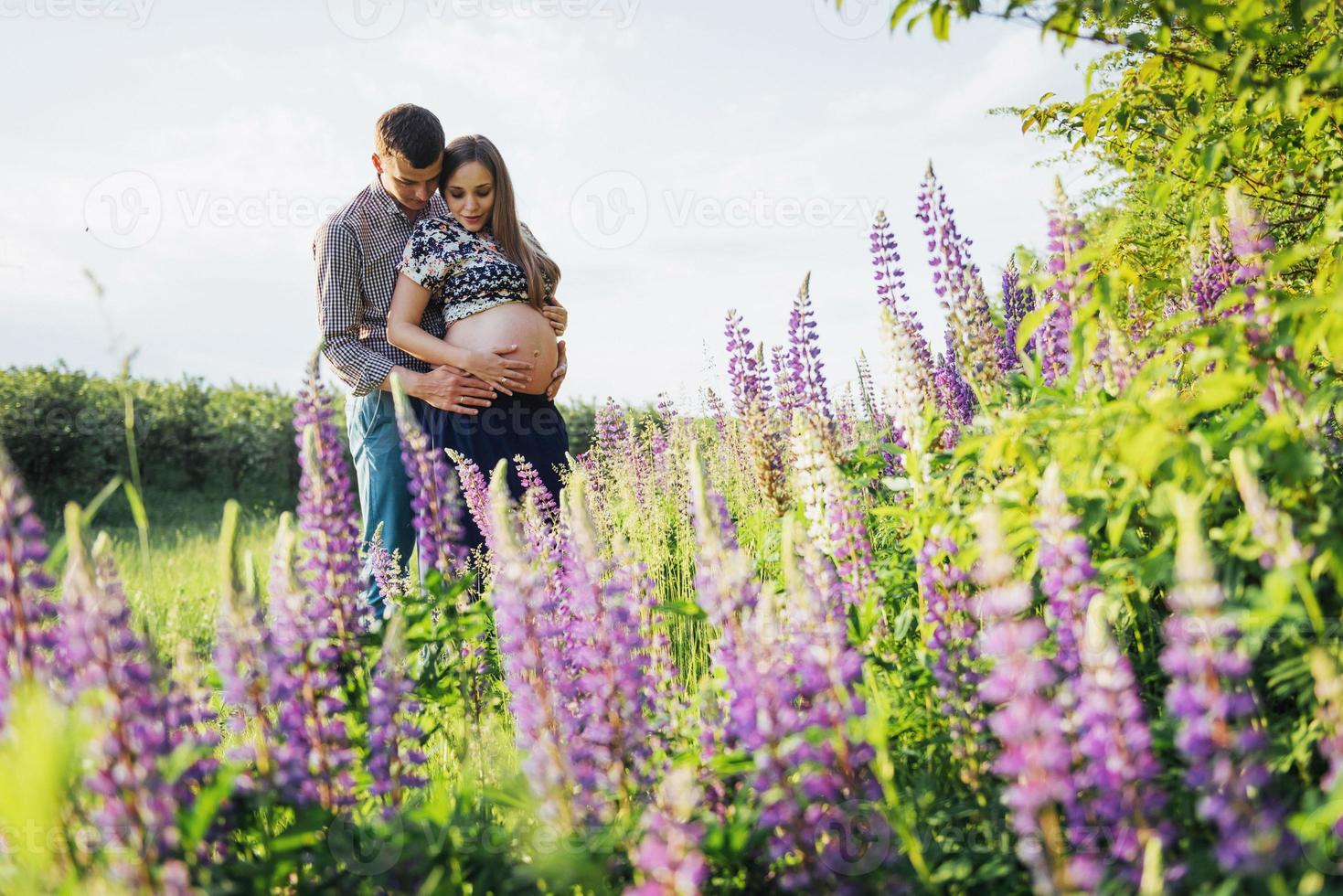 Happy beautiful girl pregnant with her husband outdoor. photo