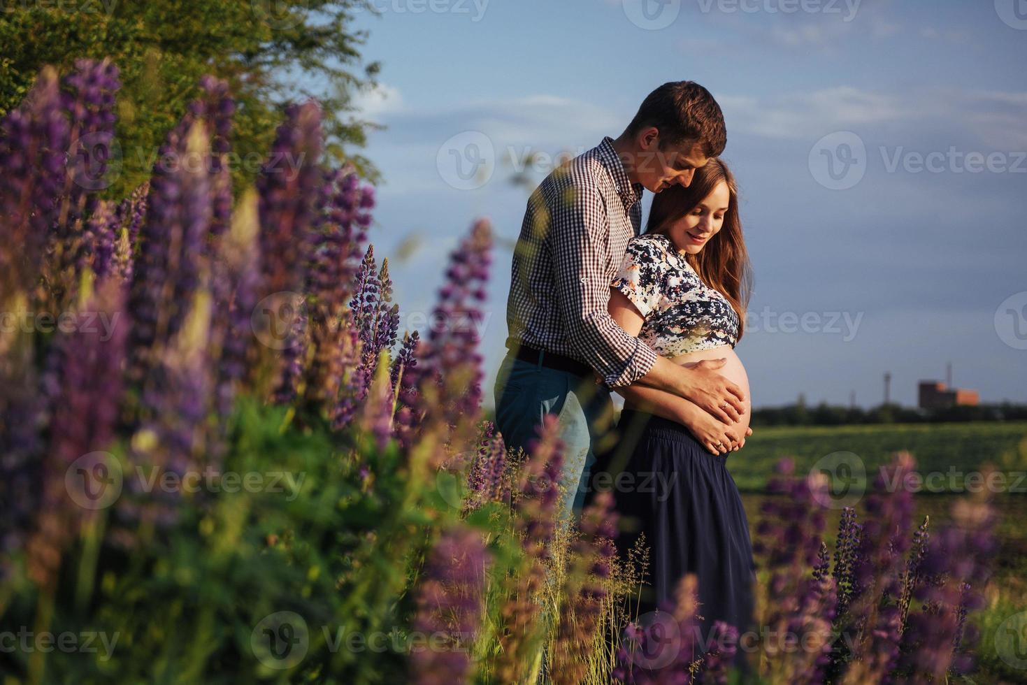 Happy beautiful girl pregnant with her husband outdoor. photo