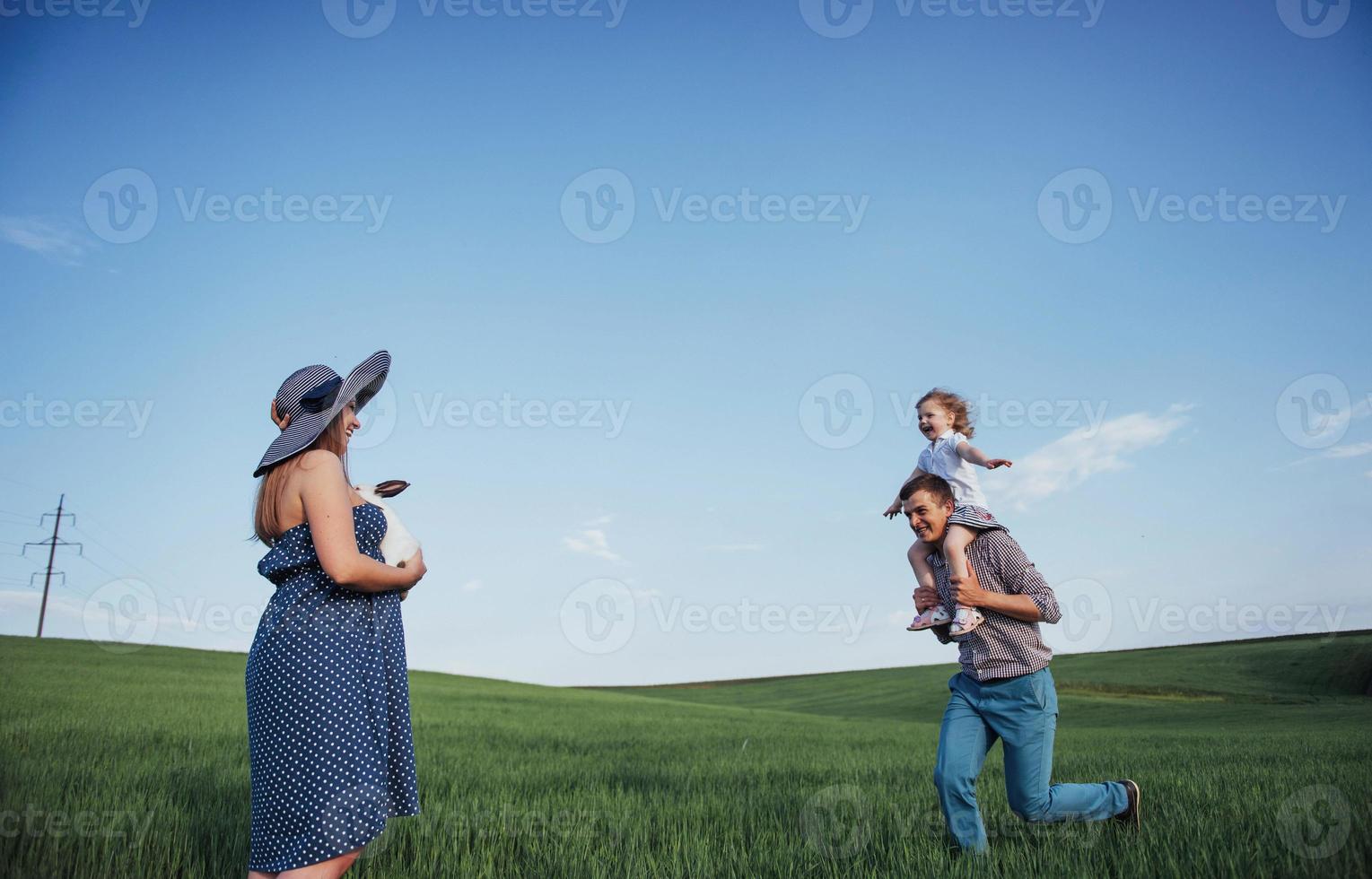 Happy family of three people hugging in the streets photo