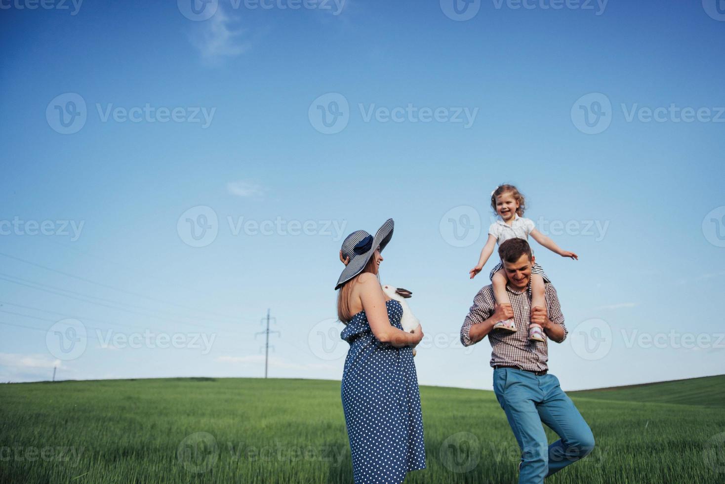 familia feliz de tres personas abrazándose en las calles foto