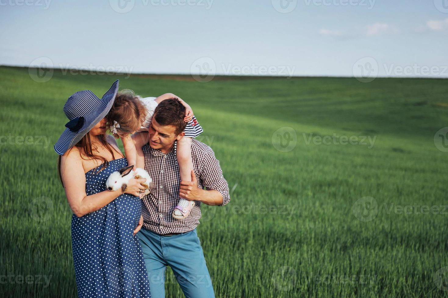 Happy family of three people hugging in the streets photo