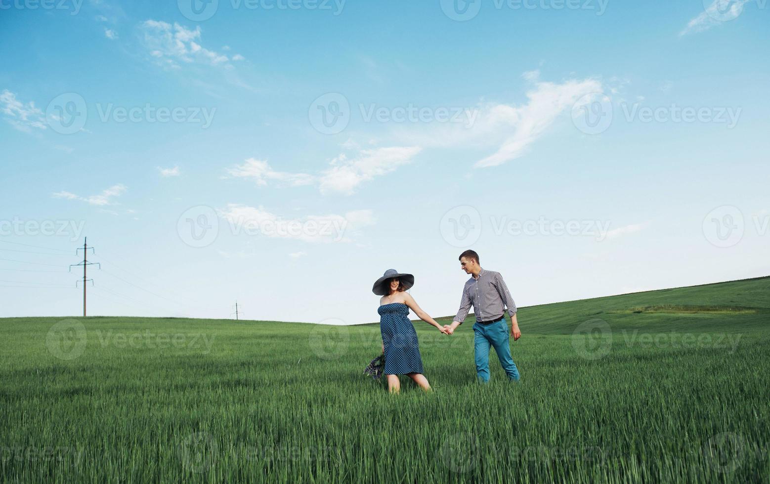 Happy family hugging in a field of green wheat photo