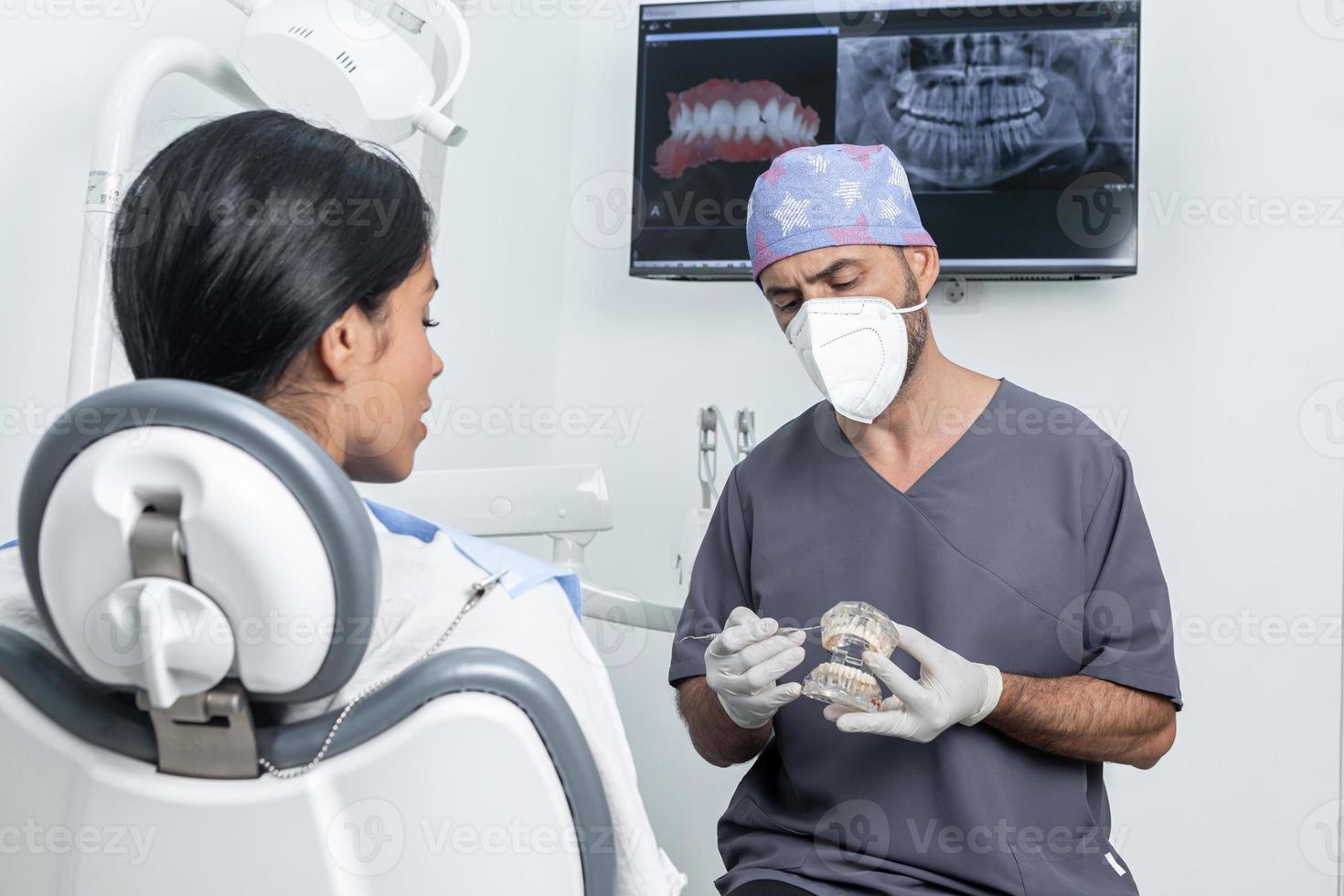 Dentist explaining to a patient how a dental mould works in a dental clinic photo