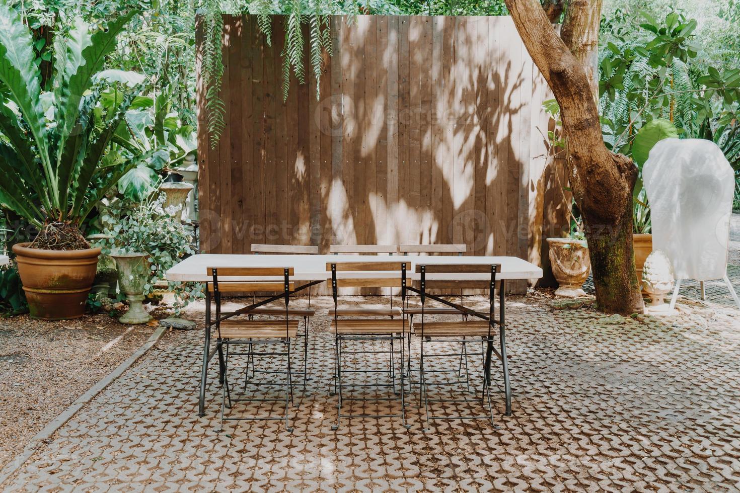 silla de madera vacía y mesa en el jardín foto