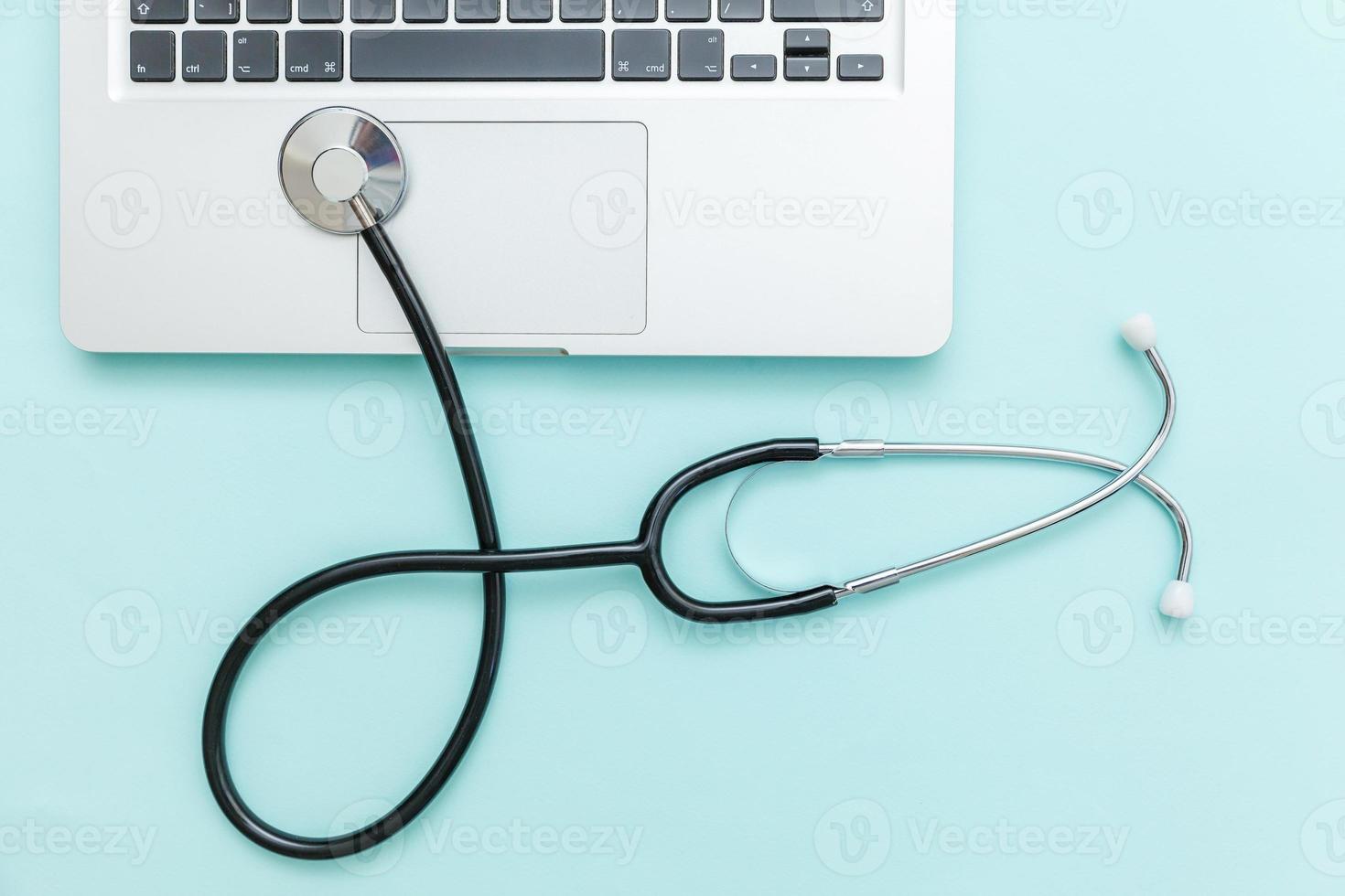 Stethoscope keyboard laptop computer isolated on blue background. Modern medical Information technology and sofware advances concept. Computer and gadget diagnostics and repair photo