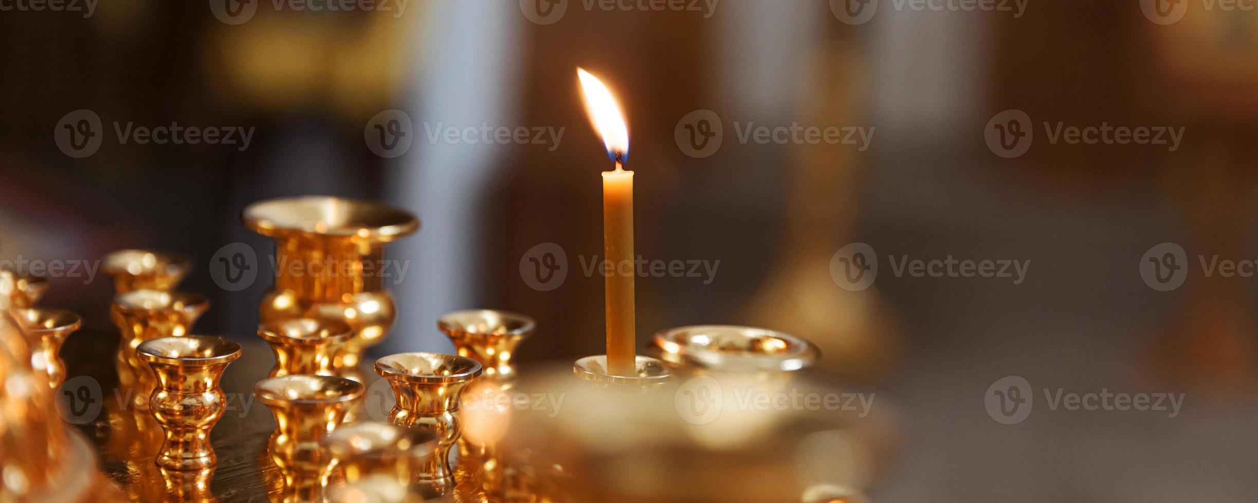 Iglesia Ortodoxa. cristiandad. decoración interior festiva con velas encendidas e icono en la iglesia ortodoxa tradicional en vísperas de pascua o navidad. religión fe orar símbolo. foto