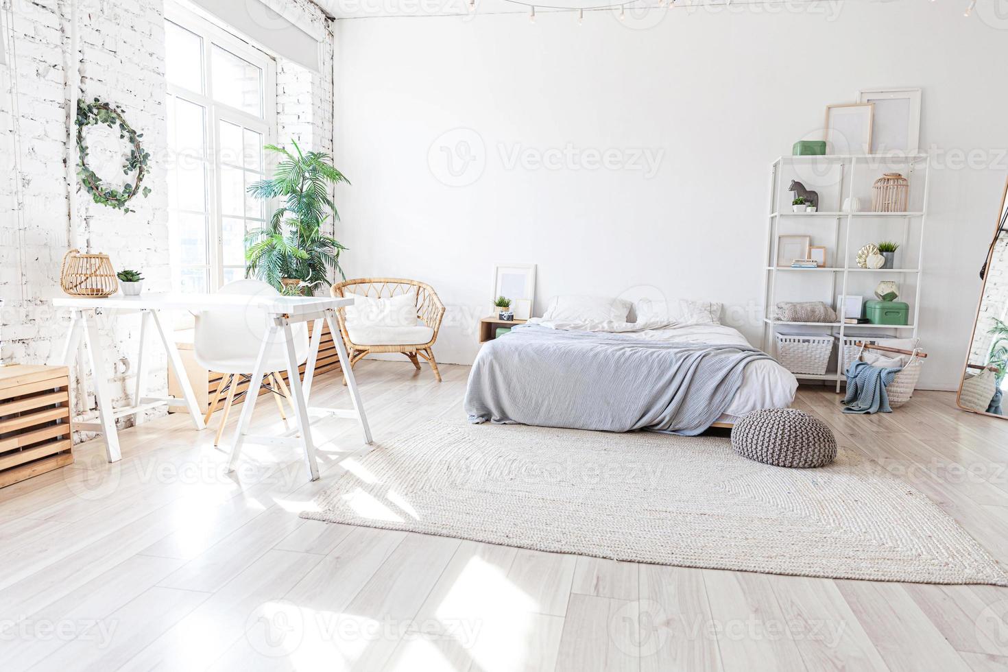 Stylish loft bedroom interior. Spacious design apartment with light walls large windows big bed. Clean modern decoration with elegant furniture in minimalist Scandinavian style. photo