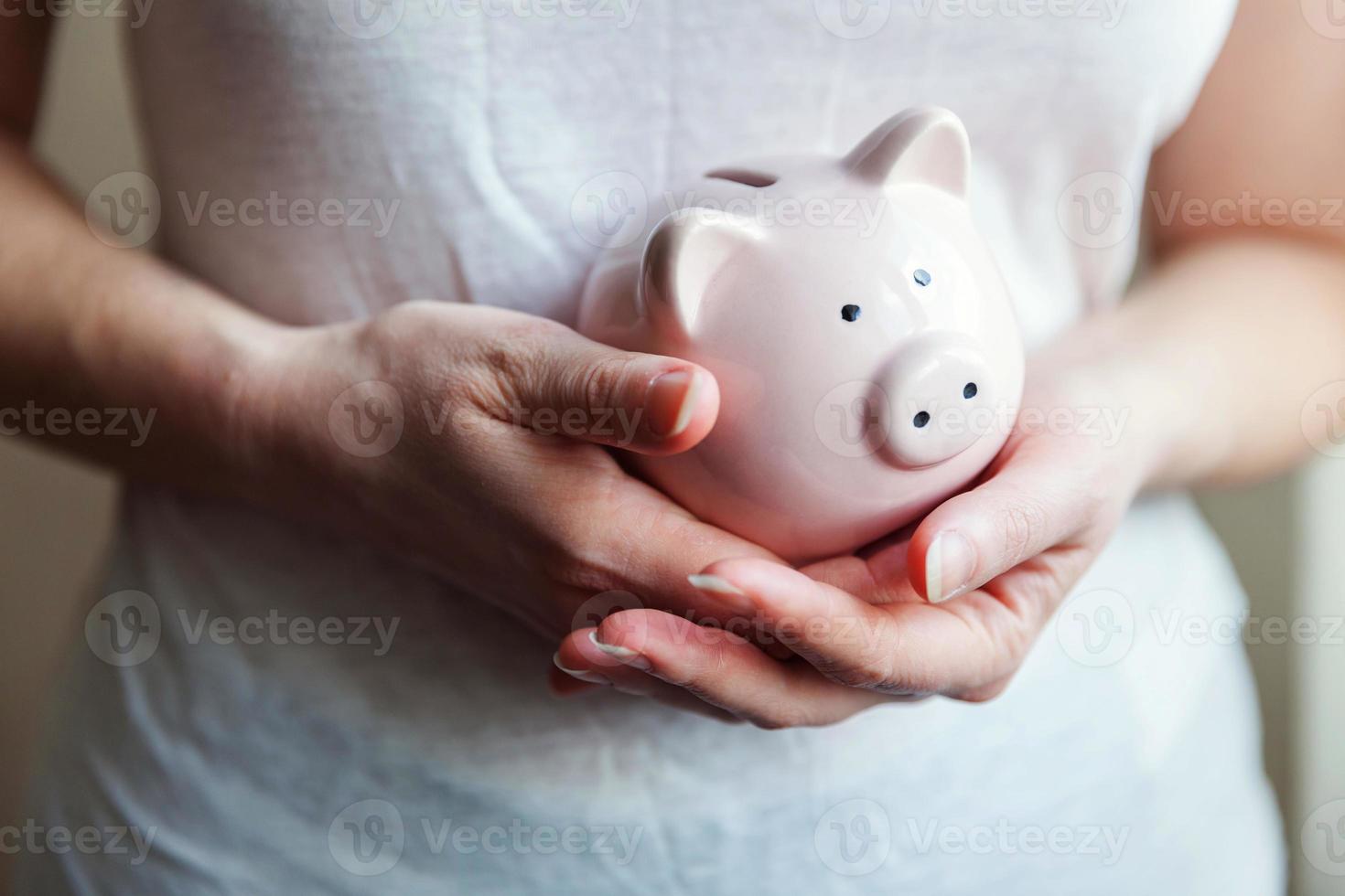 mujer mujer manos sosteniendo alcancía rosa. ahorro inversión presupuesto negocio riqueza jubilación dinero financiero banca concepto. foto