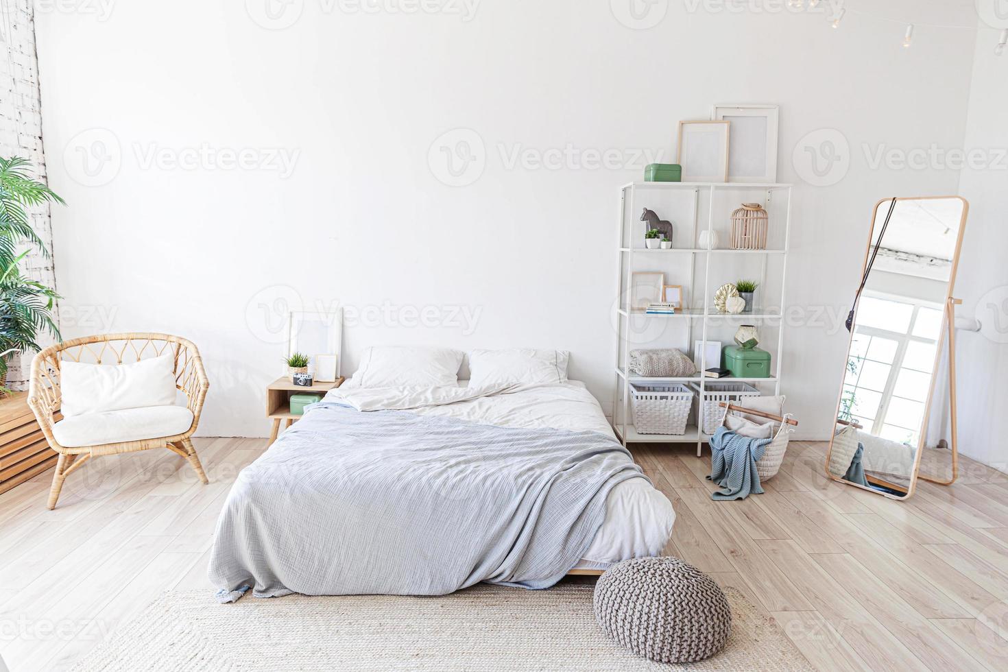 elegante interior de dormitorio tipo loft. amplio apartamento de diseño con paredes claras grandes ventanales cama grande. decoración limpia y moderna con muebles elegantes de estilo escandinavo minimalista. foto