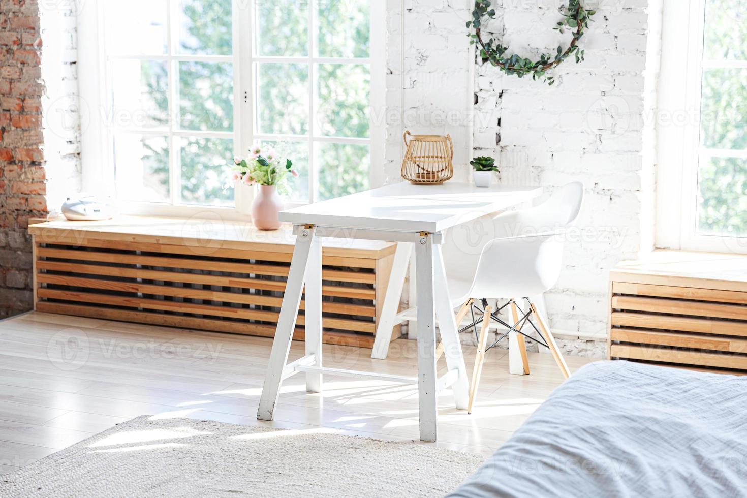 Stylish loft modern home office interior. Spacious design apartment with light walls large windows and writing desk. Clean modern decoration with elegant furniture in minimalist Scandinavian style. photo