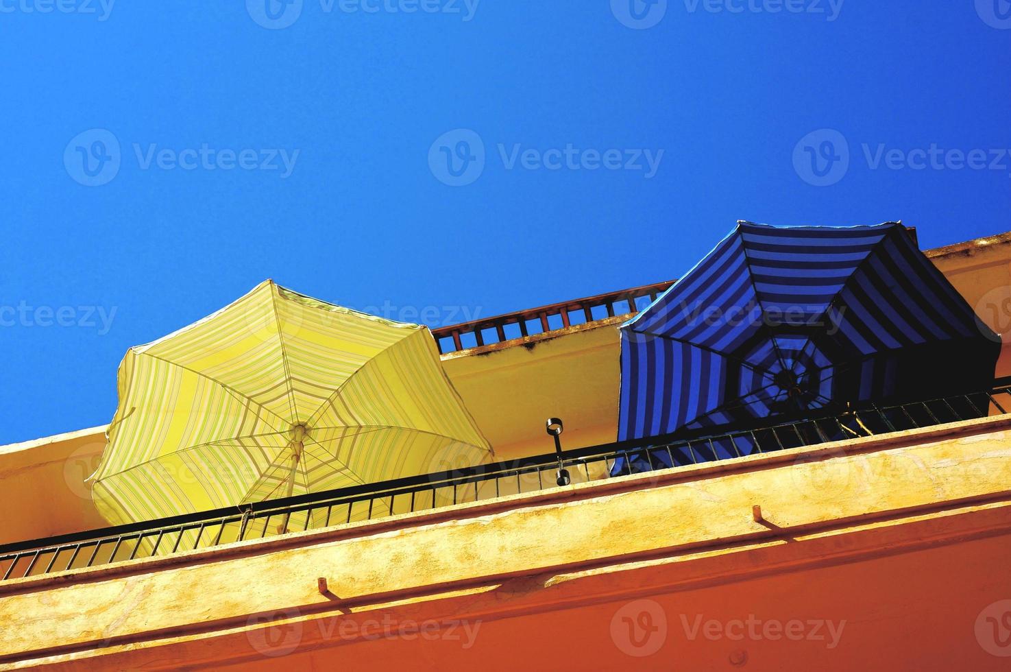 balcón con sombrilla amarilla y azul foto