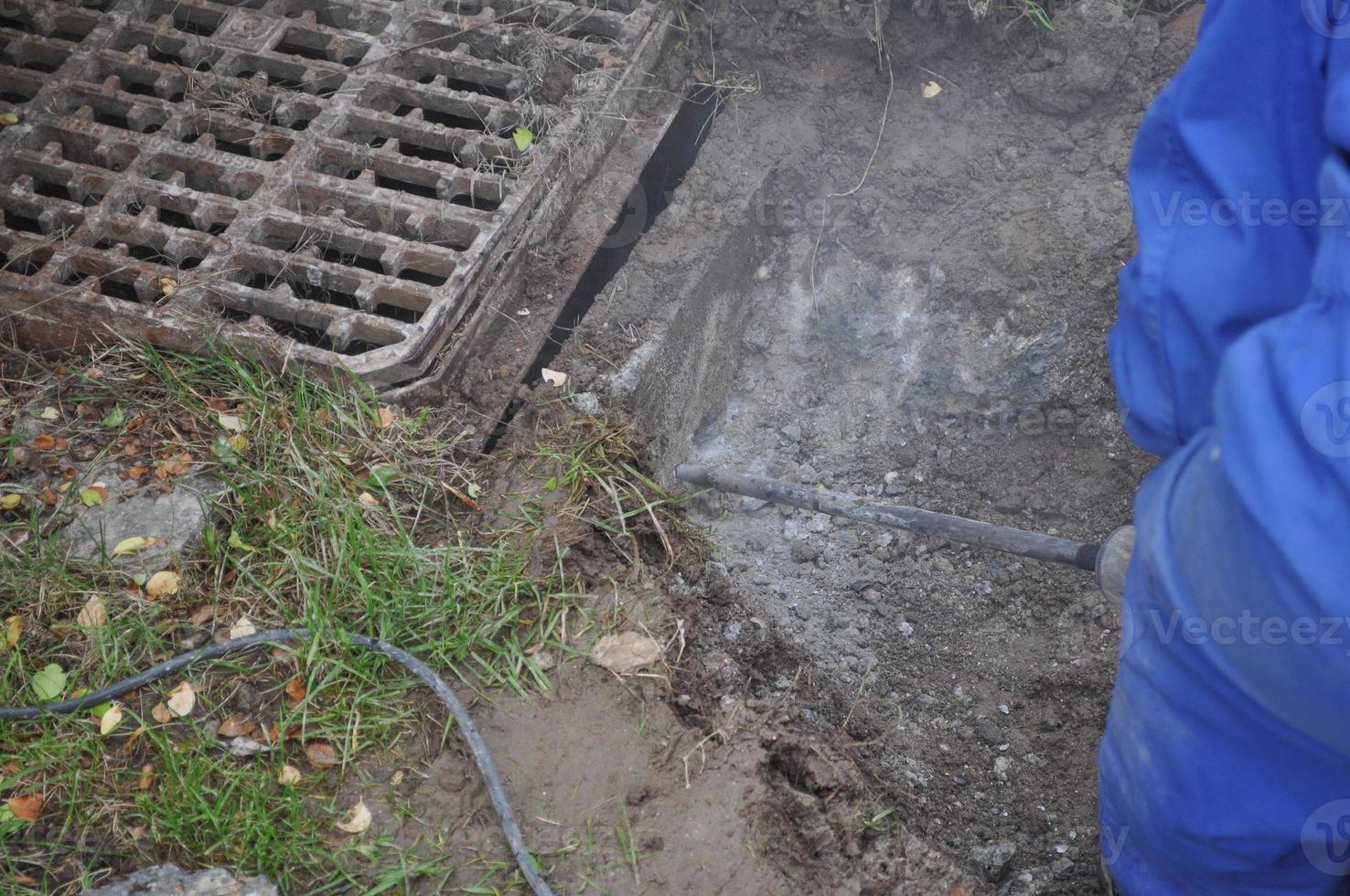 hombre trabajando en un desagüe en un sitio de construcción foto