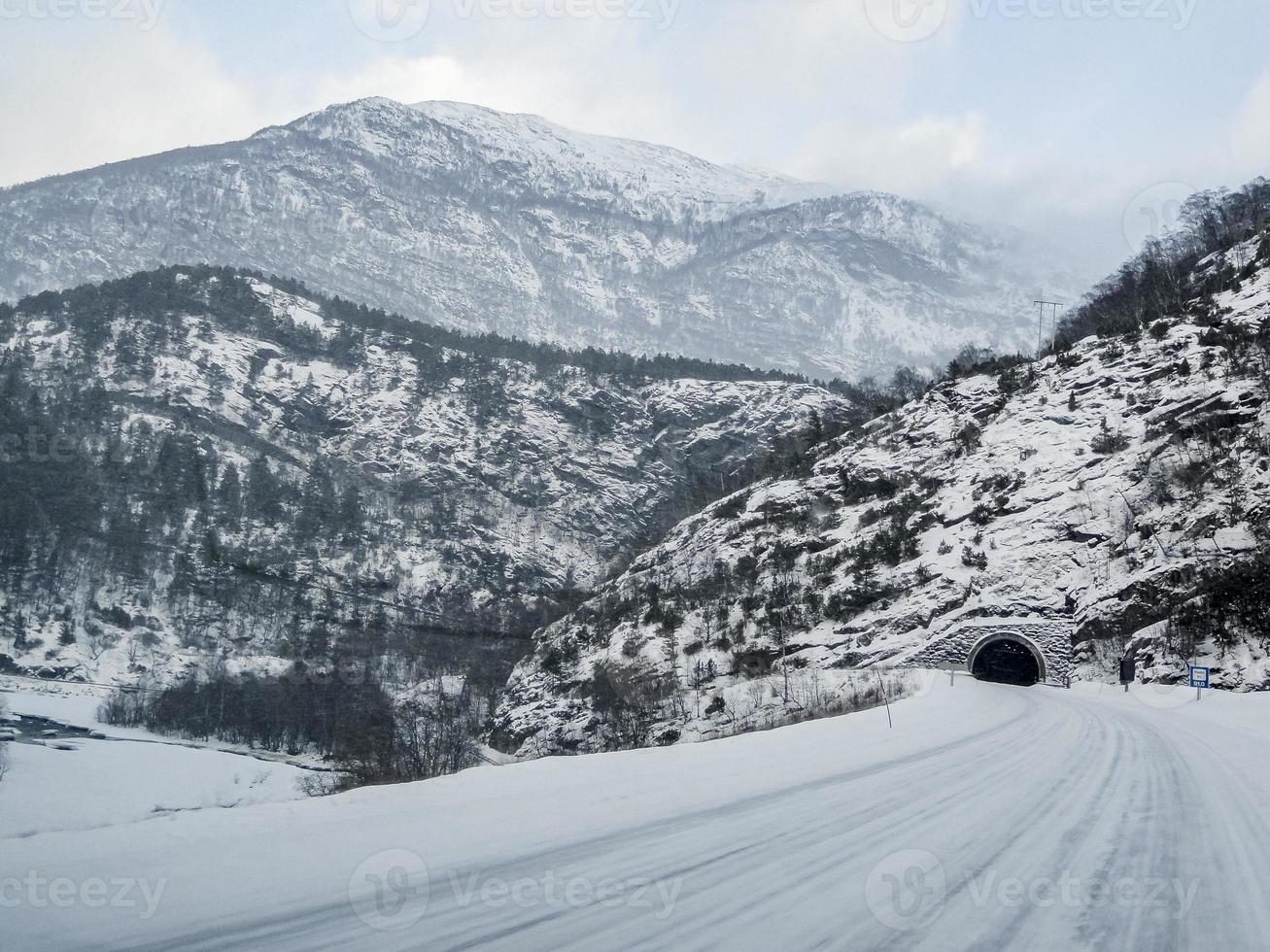 túnel frente a la carretera en el paisaje de montaña de invierno, noruega. foto