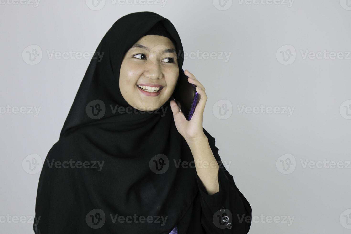 una joven islámica asiática sonriente que lleva un pañuelo en la cabeza sonríe cuando está de guardia foto