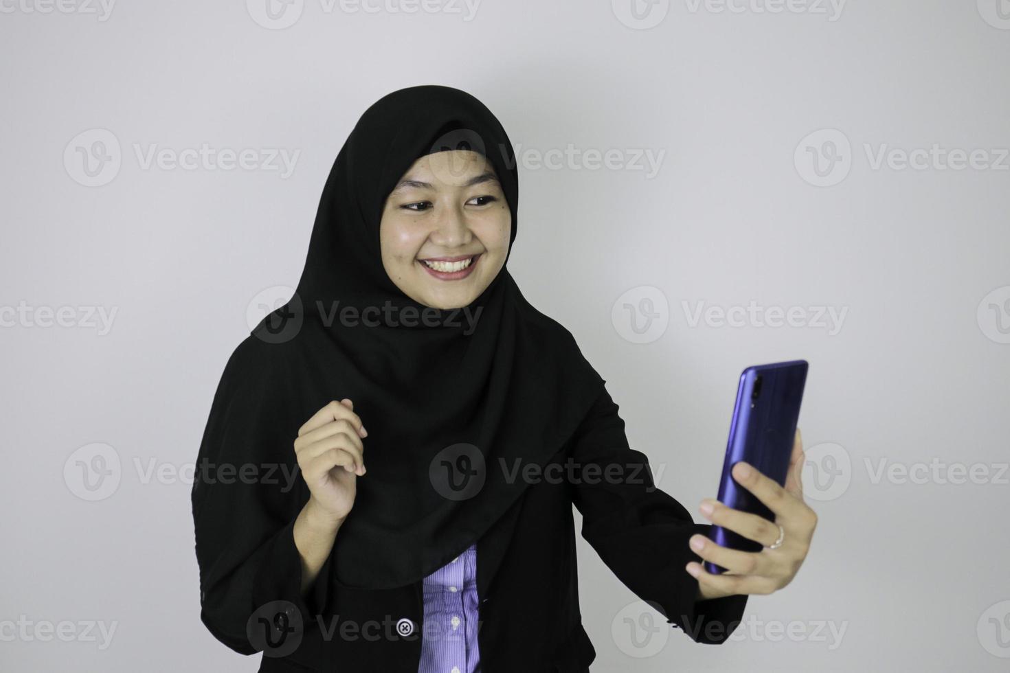 Smile Asian Islam woman wearing headscarf when video call on phone photo