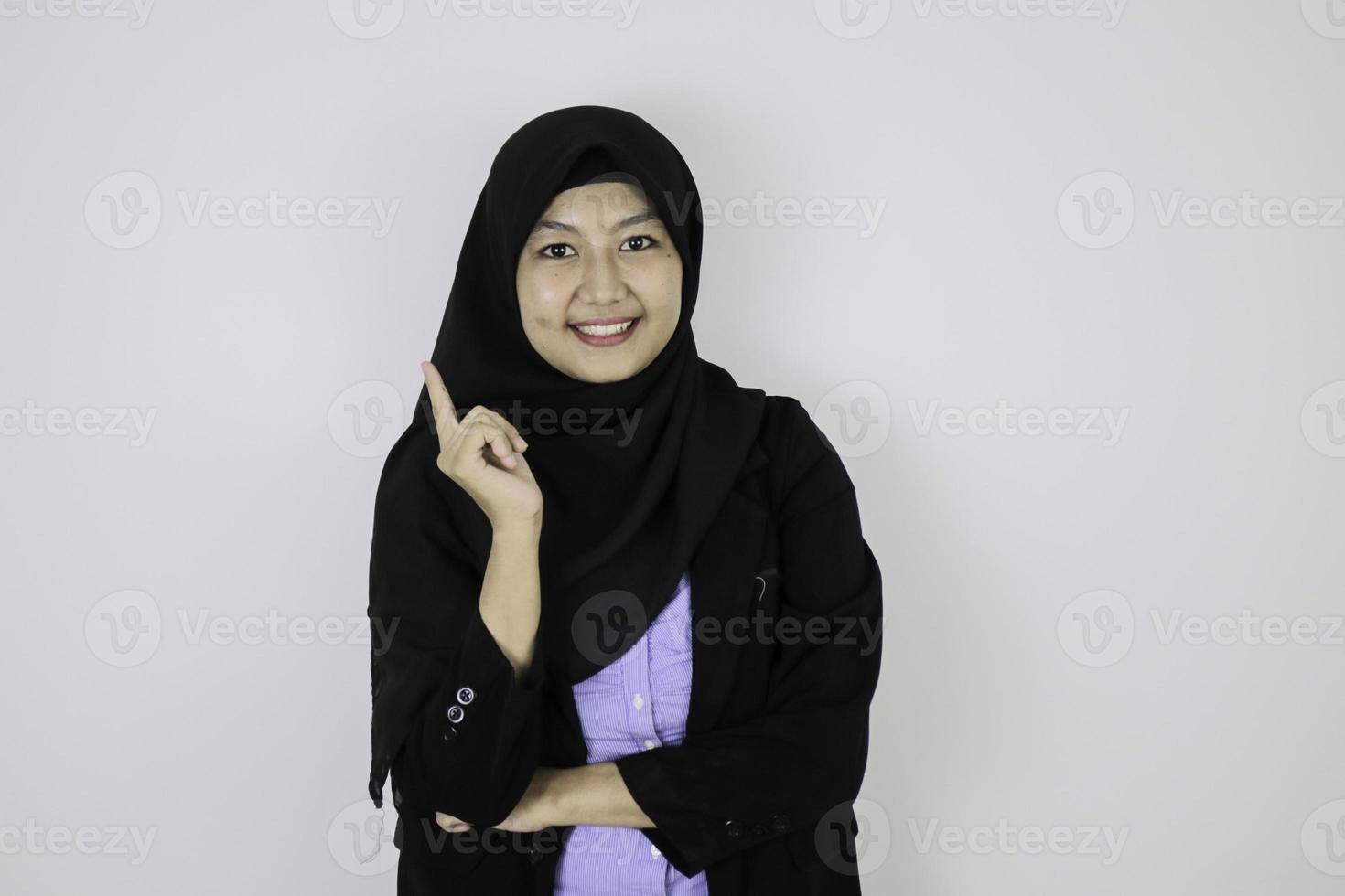 Happy Young Asian Islam woman wearing headscarf is smile and pointing beside. photo