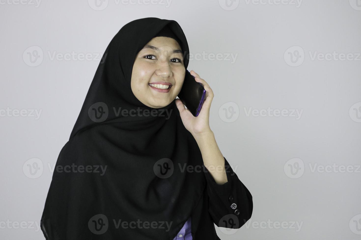 Smiling Young Asian Islam woman wearing headscarf is smile when on call photo