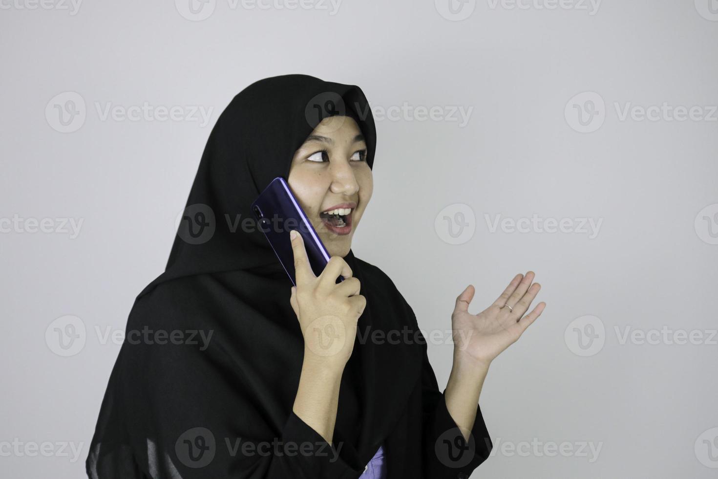 Shock gesture Young Asian Islam woman wearing headscarf when on call photo