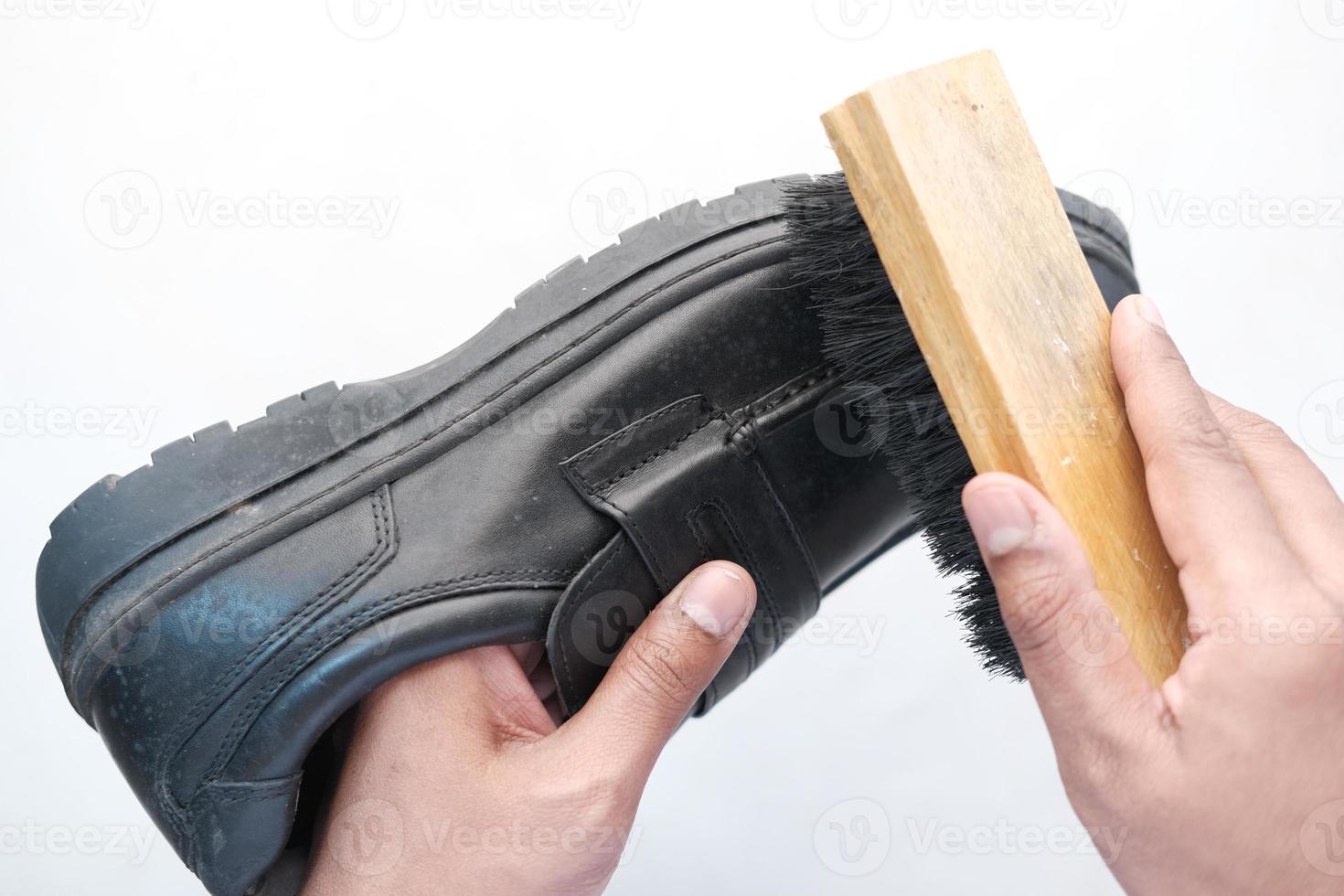 cleaning Shoe with a brush on floor photo