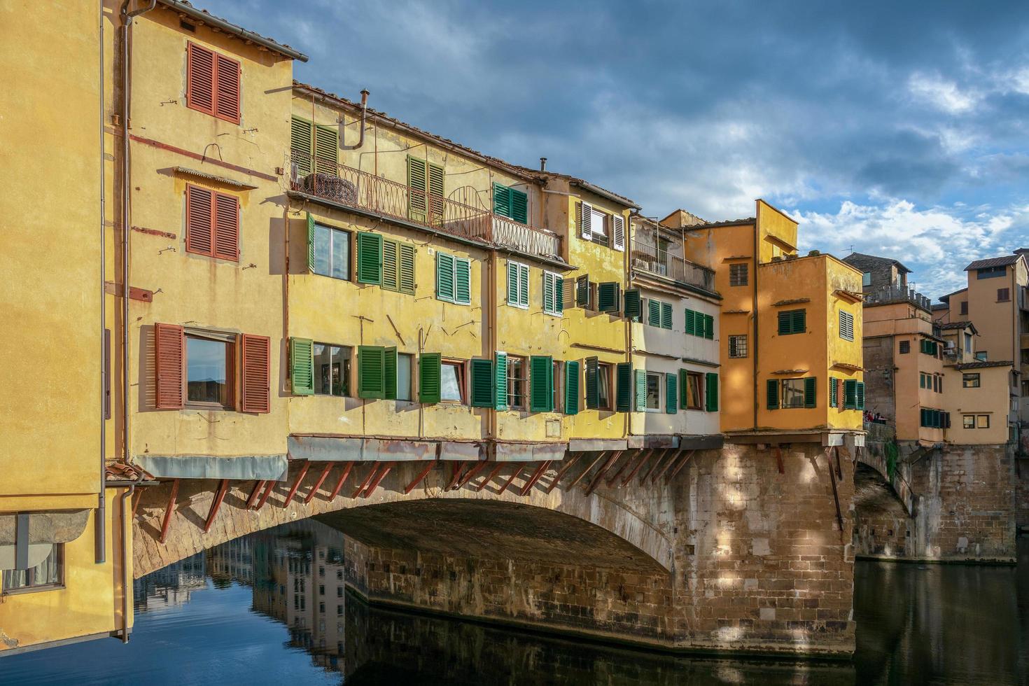 FLORENCE, TUSCANY, ITALY - OCTOBER 18.  View of buildings along and across the River Arno in Florence  on October 18, 2019. Three unidentified people. photo