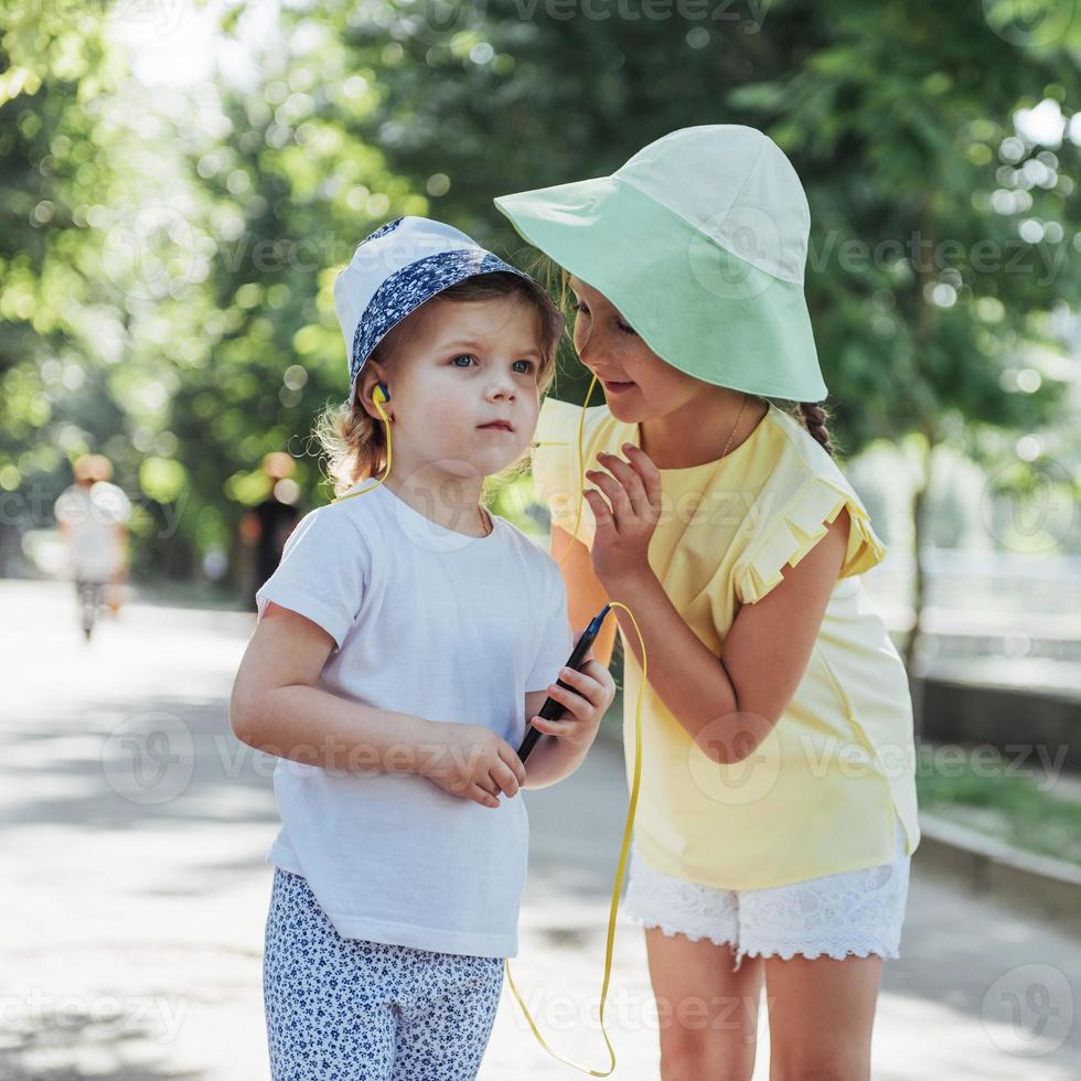 niña feliz con auriculares para compartir música foto