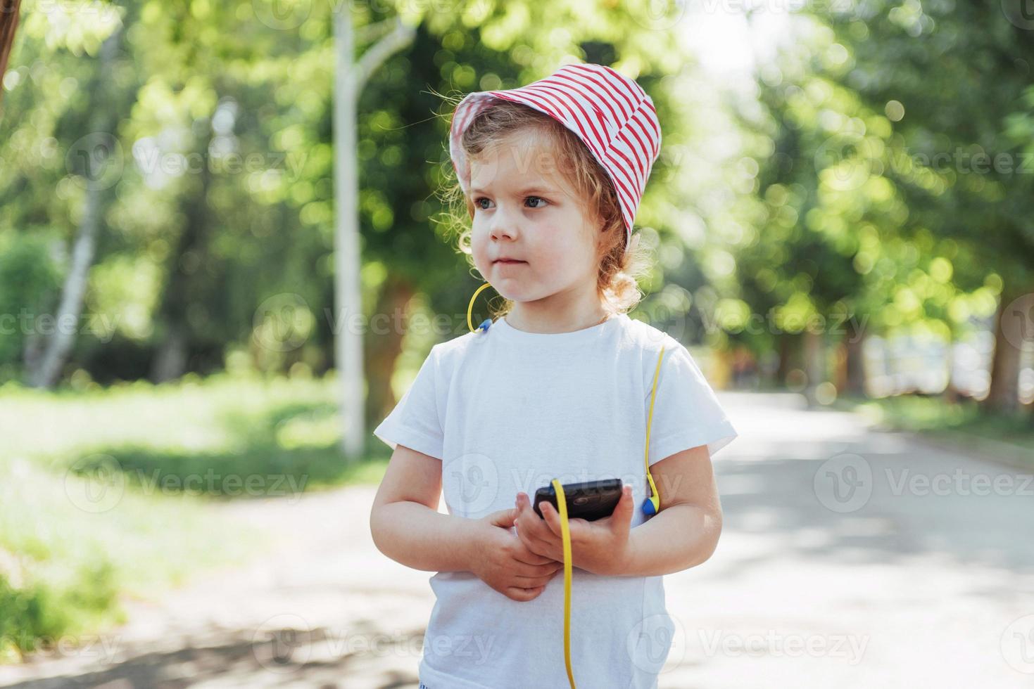 Cute girl listening to music with headphones outdoors photo