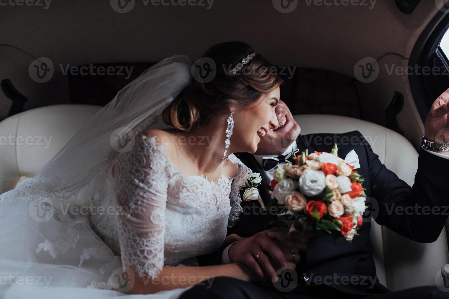 young couple in a car in wedding day photo