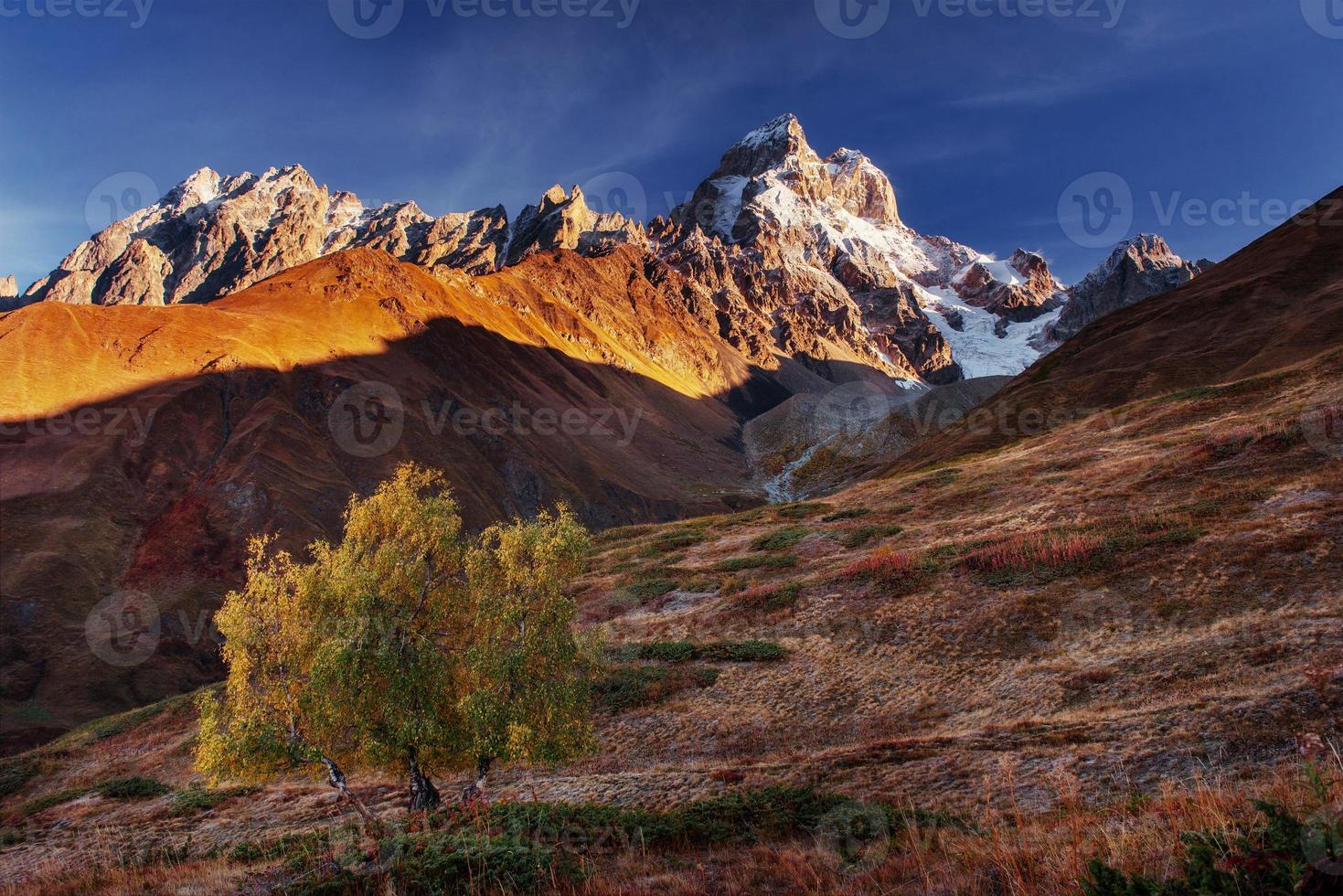 paisaje otoñal y picos montañosos nevados. foto