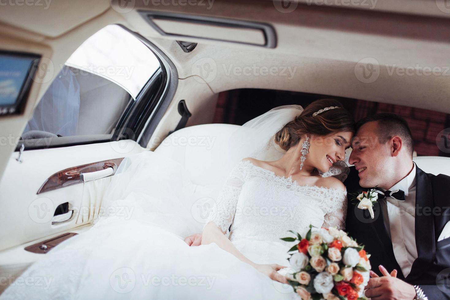 young couple in a car in wedding day photo