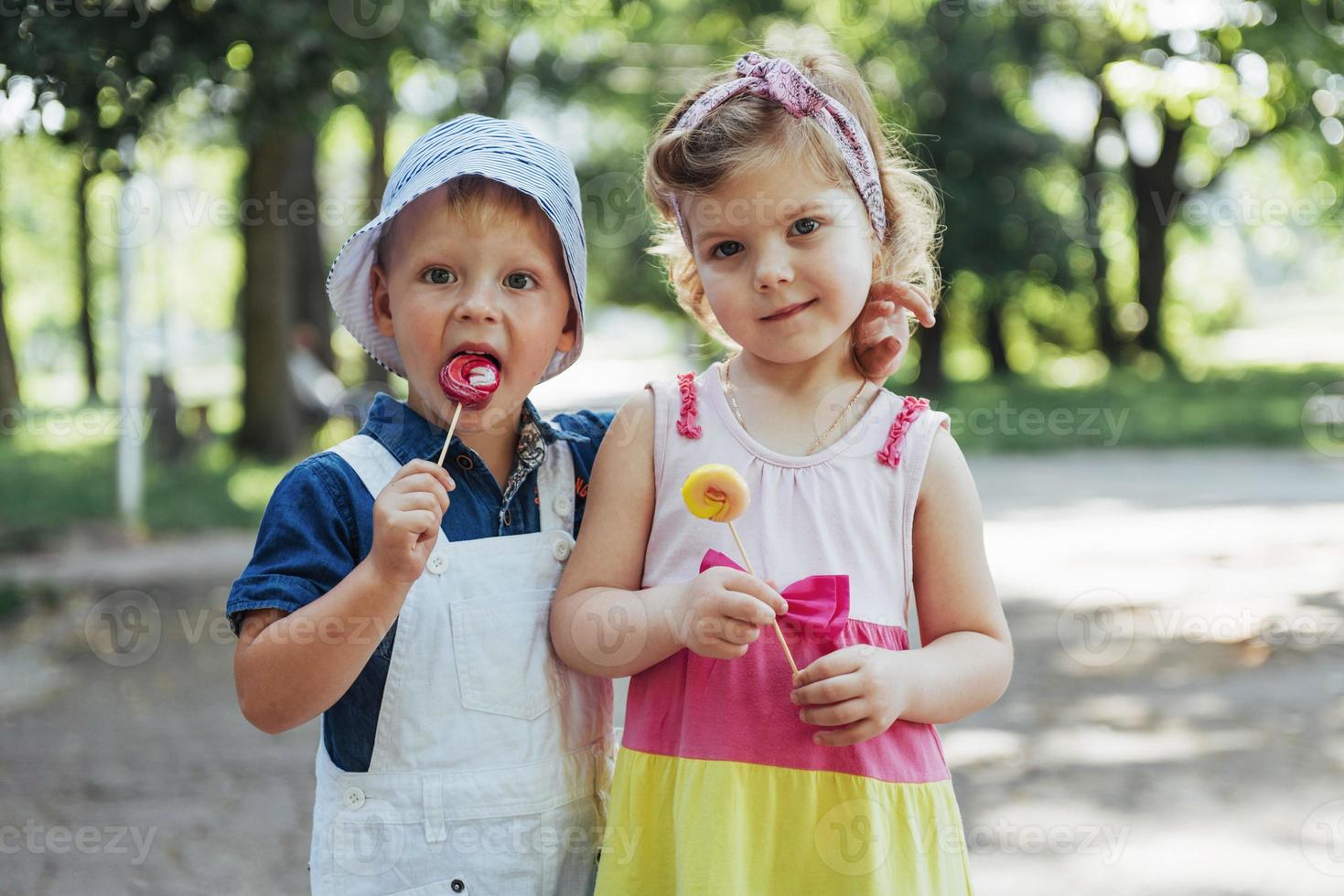 Happy children taste candy on a stick photo