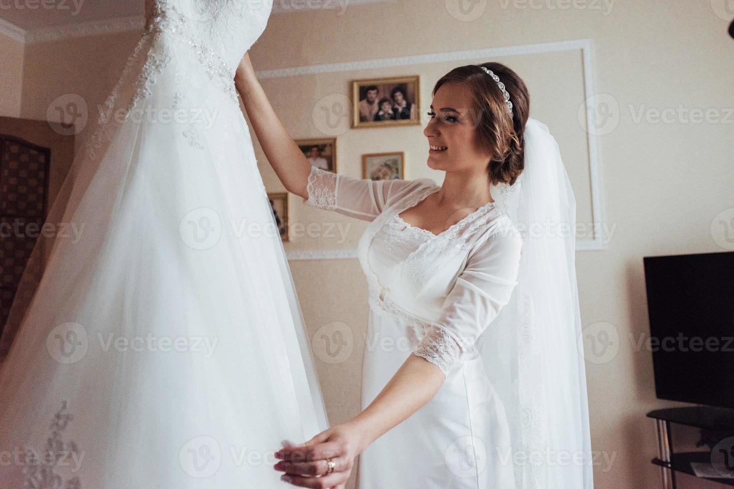 girl trying on wedding dress photo