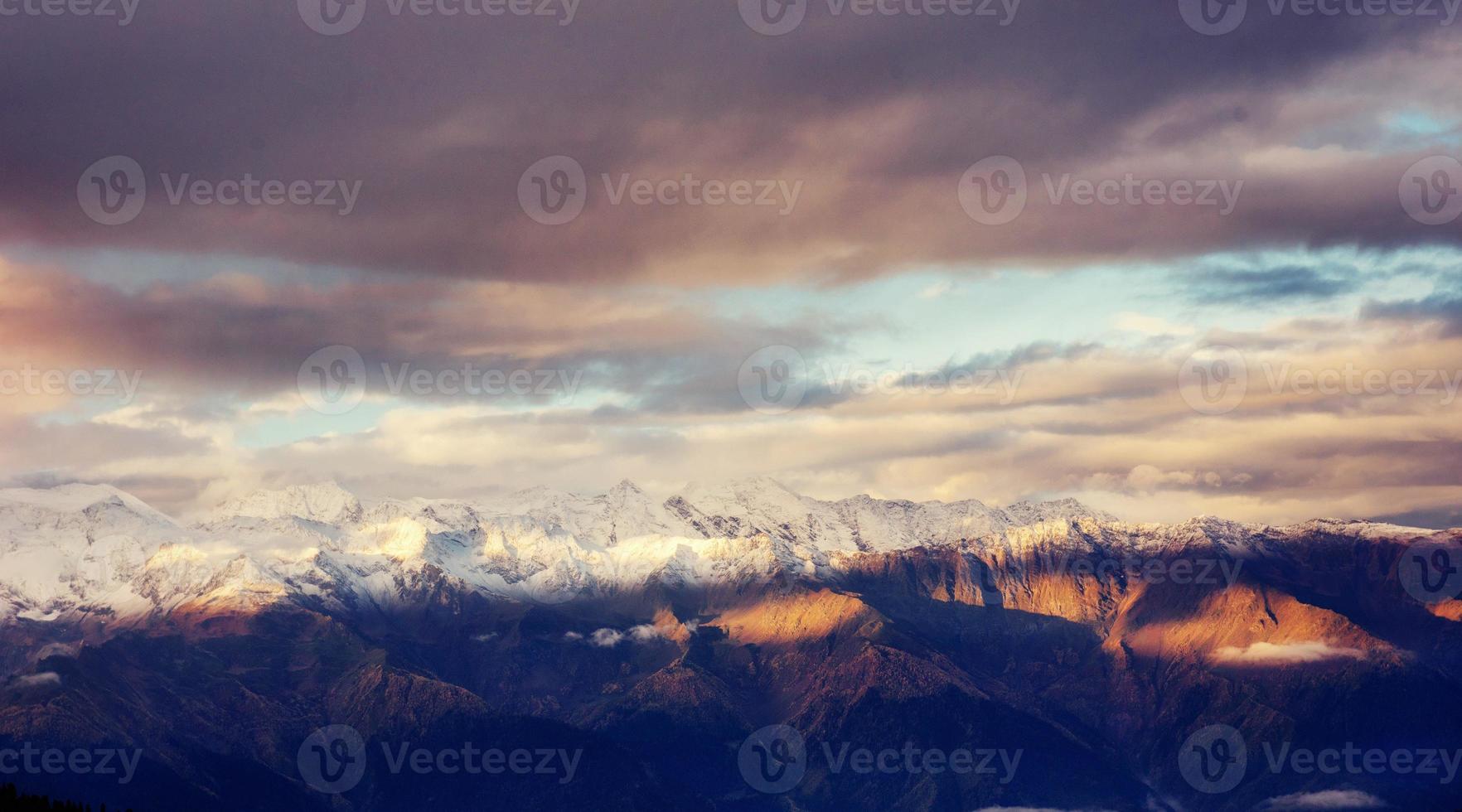 fantásticas montañas nevadas en las hermosas nubes cúmulos. foto