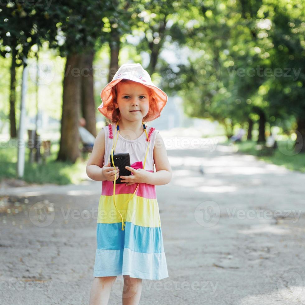 Cute girl listening to music with headphones outdoors photo