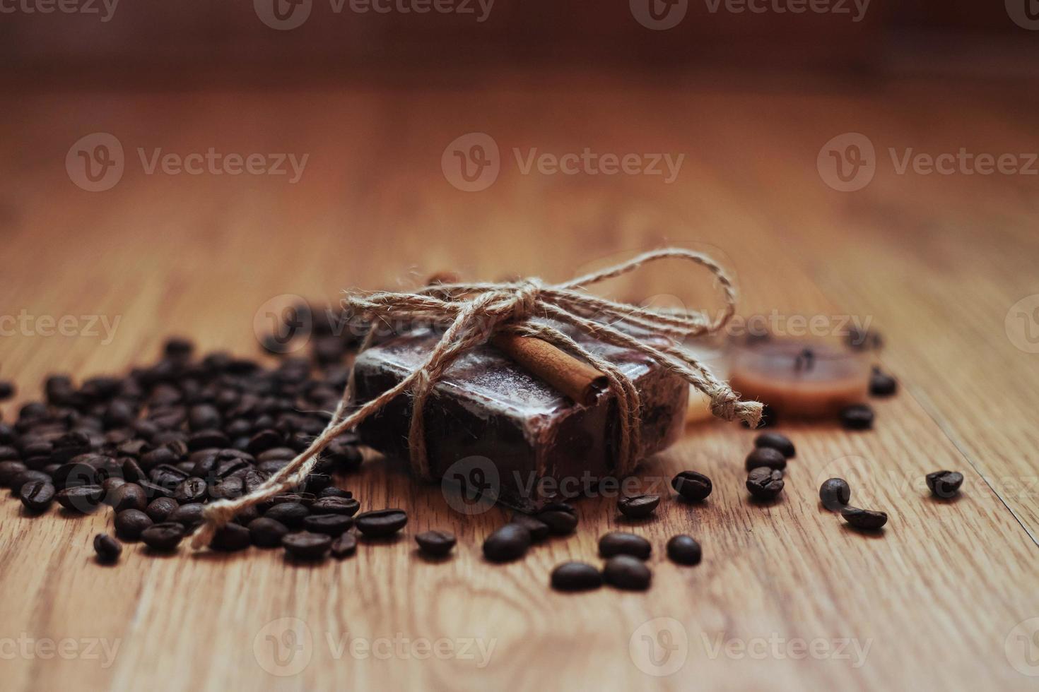 Organic soap with coffee beans and spices, on wooden background. photo