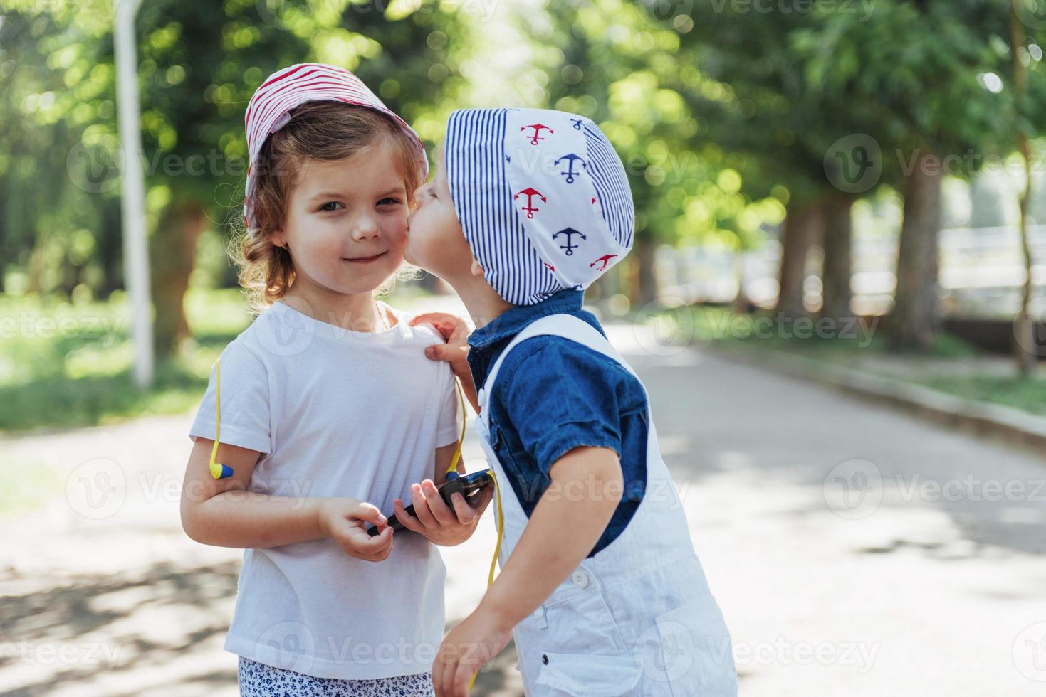 Cute girl and boy listening to music through headphones photo
