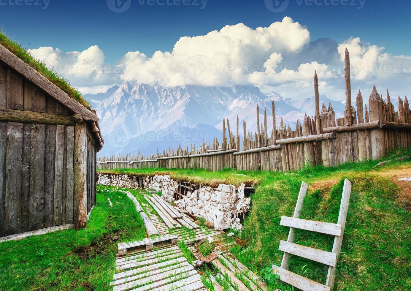 Traditional Viking village. Wooden houses near the mountain firs photo