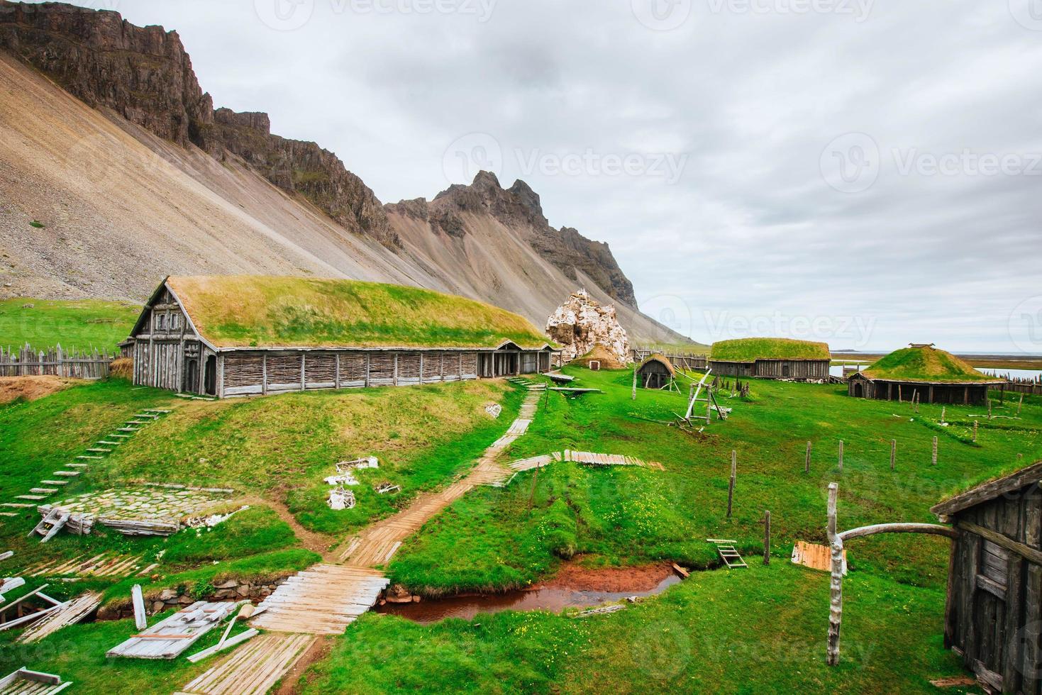 Traditional Viking village. Wooden houses near the mountain firs photo