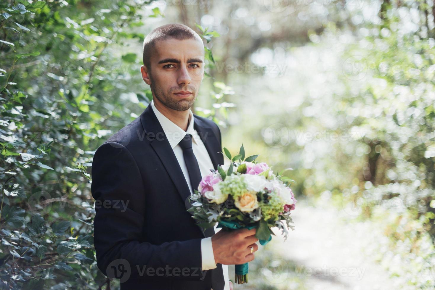 Beautiful wedding bouquet in hands of the groom photo